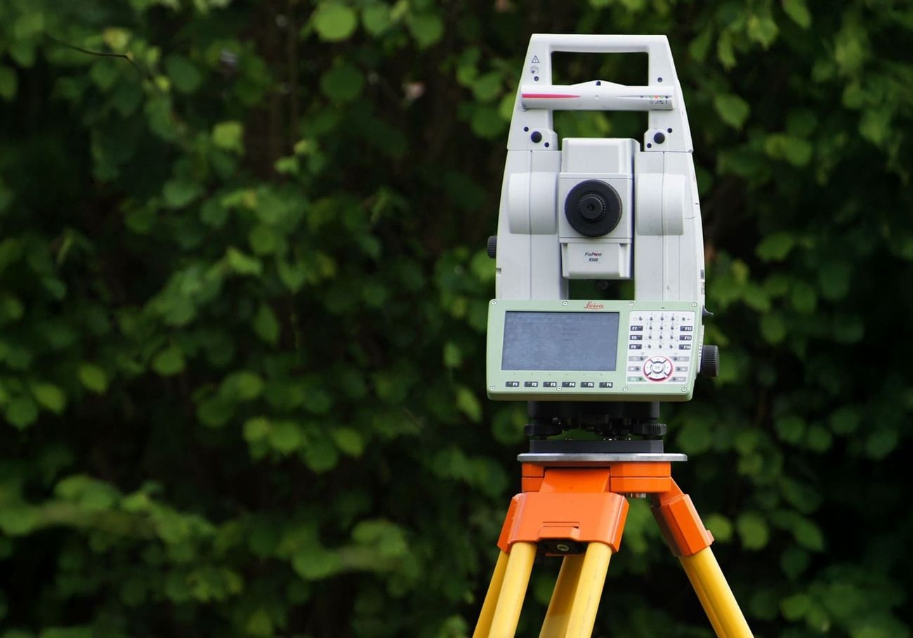 Lasergerät, das vor einer grünen Hecke steht